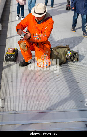 Londres, Royaume-Uni. Ben Wilson prend une photo d'un morceau de chewing-gum art sur le plancher de la Millenium Bridge. Banque D'Images