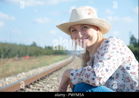 Une jeune femme blonde attendre pour locomotive, essayez d'arrêter le train Banque D'Images