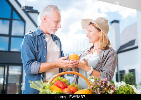 Bel homme élégant portant chemise en jean ce qui porte fruits et légumes Banque D'Images