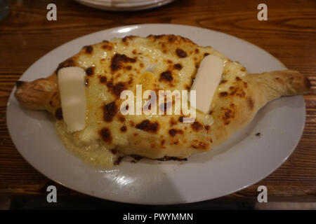 Khachapuri géorgien Ajaruli traditionnel avec des Œufs et du beurre sur une plaque Banque D'Images