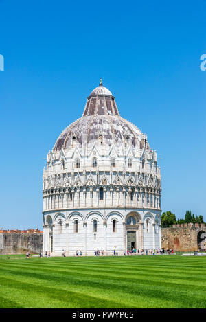 Photo verticale avec très célèbre babtistery. Ancien bâtiment est placé sur la Piazza del Duomo à côté de la tour de Pise. Pelouse verte est à l'avant et ciel bleu Banque D'Images