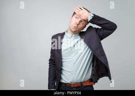 Jeune homme sérieux est fatigué après une dure journée de travail au bureau. Les gens et les expressions faciales concept Banque D'Images