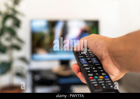 Regarder la télévision et à l'aide de remote control Banque D'Images