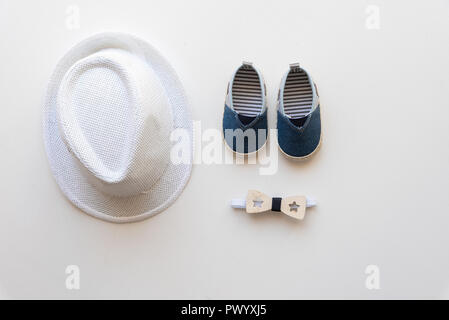 Chapeau enfant, chaussures et nœuds papillons sur fond blanc. Banque D'Images