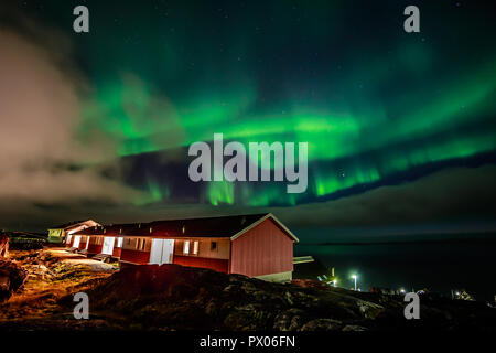 Northern Lights lumineux vert caché par les nuages plus de maisons individuelles au fjord, Nuuk, Groenland ville Banque D'Images