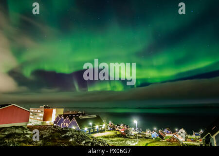 Northern Lights lumineux vert caché par les nuages sur le village Inuit au fjord, Nuuk, Groenland ville Banque D'Images