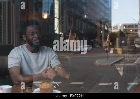 Couple en interaction les uns avec les autres dans le café Banque D'Images