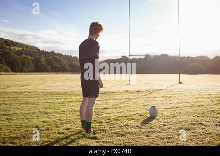 Le joueur debout avec ballon de rugby sur le terrain Banque D'Images