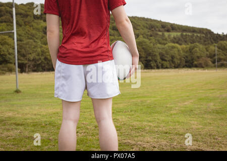 Le joueur debout avec ballon de rugby sur le terrain Banque D'Images