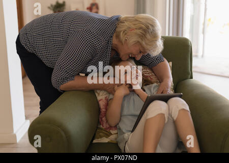 Grand-mère et petite-fille using digital tablet in living room Banque D'Images