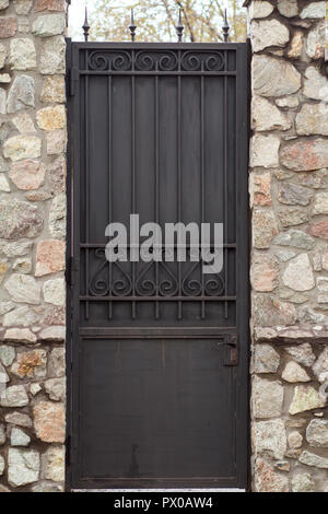 Black metal porte avec mur de pierre. Meubles anciens à la recherche d'architecture urbaine Banque D'Images