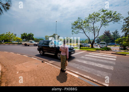 Kigali, Rwanda - 20 septembre 2018 : un piéton en attendant qu'une voiture passe à un passage à niveau près du centre-ville Banque D'Images