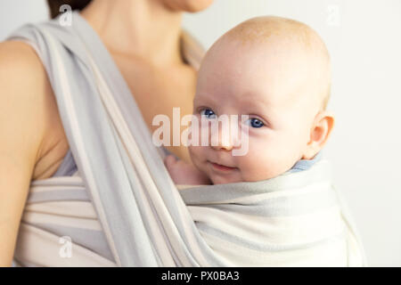 Heureux le bébé et la mère. Près de mère bébé dans une écharpe.