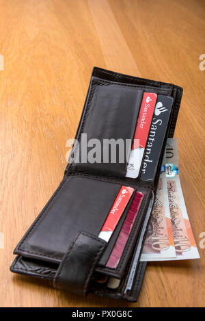 Vieux Mans Etui en cuir avec des cartes de crédit et billets de banque en livres sterling. Banque D'Images