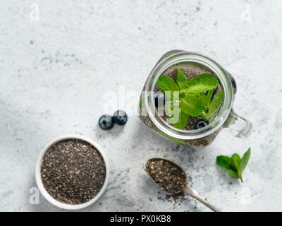 Vue du dessus de l'eau dans la région de chia pot Mason de menthe et de bleuet sur fond de ciment gris.Chia infusé avec des baies d'eau detox.Copy space for text.vue d'en haut. La saine alimentation, boissons, l'alimentation,concept detox Banque D'Images