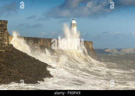 PORTHCAWL, Pays de Galles - Octobre 2018 : vague s'écraser contre le mur du port dans la lumière du soleil du soir à marée haute à Porthcawl, au Pays de Galles. Banque D'Images