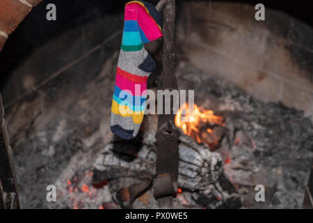 L'empoissonnement de l'épiphanie traditionnels mis en place de chaussettes holding sur fond d'incendie cheminée Banque D'Images