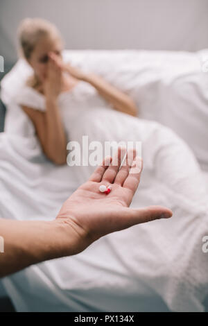 Cropped shot of man with pills in hand et femme enceinte gêne à la maison Banque D'Images