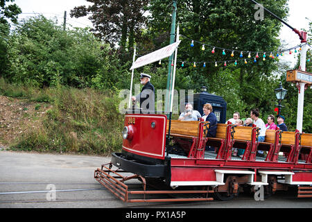 Un conducteur et les passagers d'un tram vintage ouvert à Crich Tramway Musée dans le village de Crich, Derbyshire, Royaume-Uni Banque D'Images