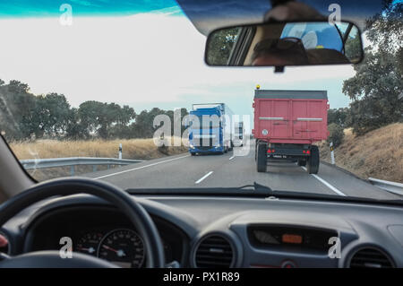Conduire lentement derrière un tracteur avec des camions dans l'autre voie. Scène de conduite Banque D'Images