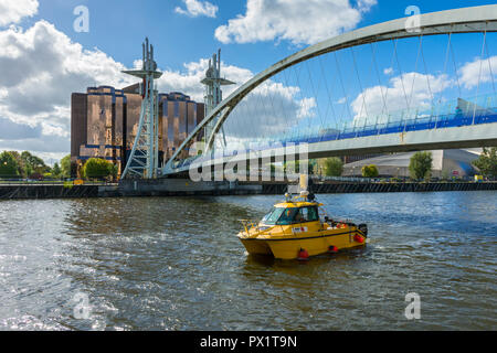 L'embarcation de Hydromap Bibby 'Pulsar' ci-dessous, le Millennium Bridge, Salford Quays, Manchester, Angleterre, Royaume-Uni. Quay West bâtiment derrière. Banque D'Images