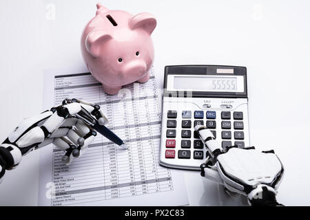 Close-up of Robot Rapport financier l'examen avec la calculatrice de bureau Banque D'Images