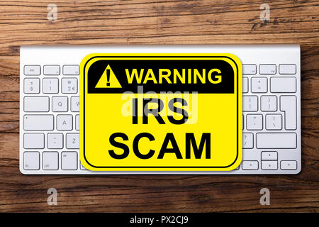 Portrait d'IRS Scam Warning Sign On Clavier fond de bois Banque D'Images