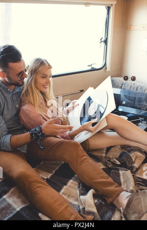 Couple assis à l'intérieur d'un camping-car hippie avec vinyl records Banque D'Images