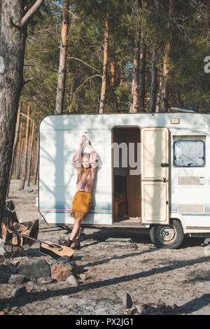 Belle jeune fille hippie près de campervan en forêt Banque D'Images