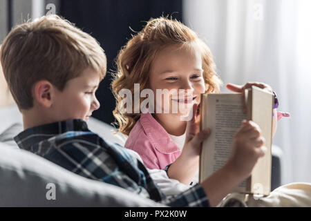 Little Boy reading book alors que sa sœur l'interrompre Banque D'Images