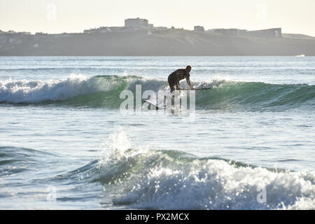 Newquay, Cornwall, Angleterre. Septembre 2018. Un mâle paddle sur le Watergate Bay Beach sur un après-midi ensoleillé à l'automne Banque D'Images