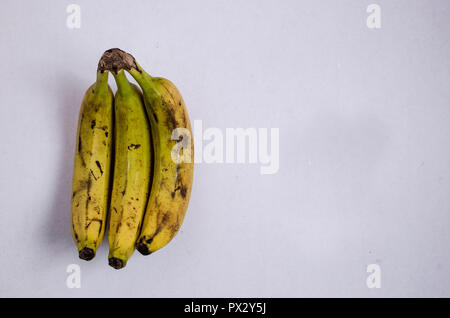 Groupe de trois bananes mûres, isolé sur un fond blanc, cliché pris à partir de ci-dessus. Banque D'Images