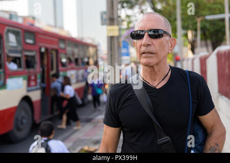 Senior homme chauve touristique pensée tout en portant des lunettes de soleil à la Banque D'Images