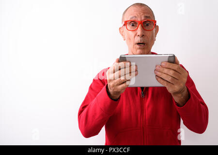 Studio shot of bald man using digital tablet whil Banque D'Images