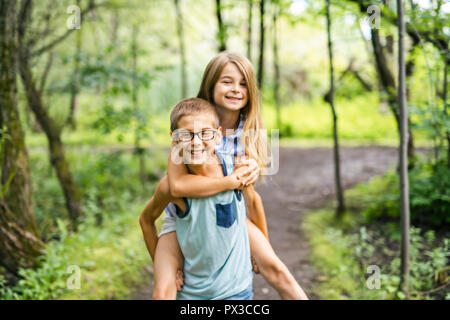 Frère et soeur de ferroutage donnant dans la forêt Banque D'Images