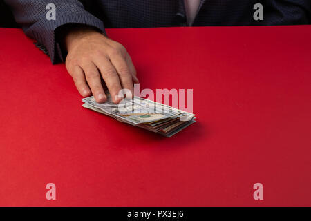 Selective focus,Man lot de centaines de dollars. Mains de près. La vénalité, corruption, pot-de-concept. Part le fait de donner de l'argent - United States Dol Banque D'Images
