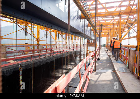 19 octobre 2018, Bade-Wurtemberg, Mühlhausen im Täle : deux hommes à pied le long du coffrage de béton dans laquelle le pont est versé sur le site de construction du pont sur le Filstal Aichelberg. Le pont fait partie de la nouvelle section de l'Wendlingen-Ulm projet ferroviaire Stuttgart 21. Une fois terminé, il sera d'environ 800 mètres de long et 50 mètres de haut. Photo : Sebastian Gollnow/dpa Banque D'Images