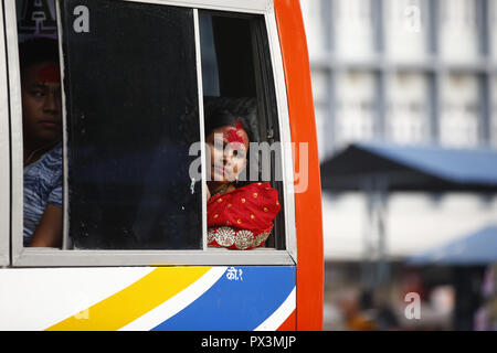 Dharan, au Népal. 19 Oct, 2018. Une femme népalaise avec Tika appliqué sur son front s'ouvre une fenêtre d'un autobus au cours de Tika, le dixième jour de Dashain festival à Katmandou, Népal le Vendredi, Octobre 19, 2018. Anciens mettre tika et jamara sur le front de la famille plus jeunes de les bénir avec abondance dans les années à venir. Vijaya Dashami symbolise la victoire du bien sur le mal et est considéré comme le plus grand et le plus long festival de l'hindous népalais. Credit : Skanda Gautam/ZUMA/Alamy Fil Live News Banque D'Images