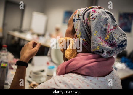 Mainz, Allemagne. 19 Oct, 2018. 19 octobre 2018, l'Allemagne, Mainz : une femme nettoie sa peau avec le cancer dans la classe. Le traitement du cancer par chimiothérapie ou radiothérapie peut considérablement modifier l'apparence du patient avec la perte de cheveux, perte de cils et sourcils ou l'irritation de la peau. Le fichier de donneurs de moelle osseuse, Allemand (DKMS) propose pour les femmes concernées en particulier sur il a coordonné les cours de mise à niveau. Crédit : Andreas Arnold/dpa/Alamy Live News Banque D'Images