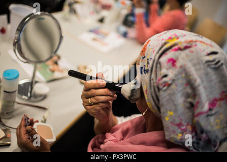 Mainz, Allemagne. 19 Oct, 2018. 19 octobre 2018, l'Allemagne, Mainz : une femme atteinte d'un cancer s'applique avec un pinceau cosmétique pendant un cours de maquillage. Le traitement du cancer par chimiothérapie ou radiothérapie peut considérablement modifier l'apparence du patient avec la perte de cheveux, perte de cils et sourcils ou l'irritation de la peau. Le fichier de donneurs de moelle osseuse, Allemand (DKMS) propose pour les femmes concernées en particulier sur il a coordonné les cours de mise à niveau. Crédit : Andreas Arnold/dpa/Alamy Live News Banque D'Images