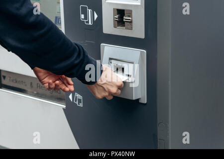 Achète les billets pour les touristes ou le métro en Allemagne. Achat de billets pour indépendants le tram, bus et train dans une rue moderne machine. Met de l'argent dans un trou dans la machine Banque D'Images