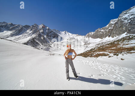 Model posing dans un maillot de bain et matériel de ski dans les montagnes. Banque D'Images