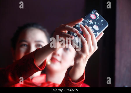 Filles vietnamiennes avec longue robe traditionnelle Ao Dai faisant des photos avec un smartphone. Ho Chi Minh Ville. Le Vietnam. Banque D'Images