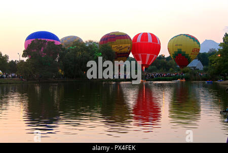 L'air chaud baloons voler dans le ciel du soir près du lac Banque D'Images