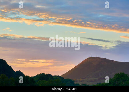 Vue de Pen de DIN et le Monument de Wellington avec le soleil bas reflétant sur les nuages au coucher du soleil près de Penpercau, au nord du Pays de Galles, Royaume-Uni Banque D'Images