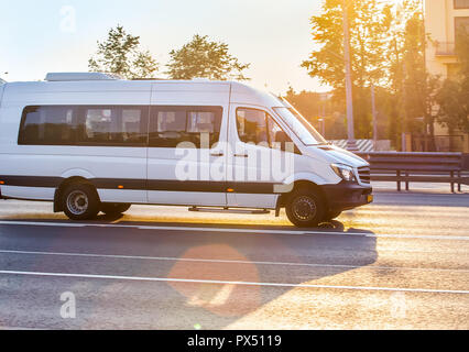 Minibus blanc va sur la ville street Banque D'Images