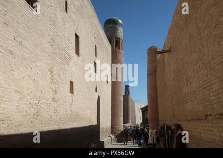 Les gens marcher dans une ruelle étroite à l'Ichan-Kala ville historique de Khiva l'ancienne capitale de Khwarezmia et le Khanat de Khiva répertorié comme site du patrimoine mondial de l'Unesco situé dans la région de l'Ouzbékistan, Xorazm Banque D'Images