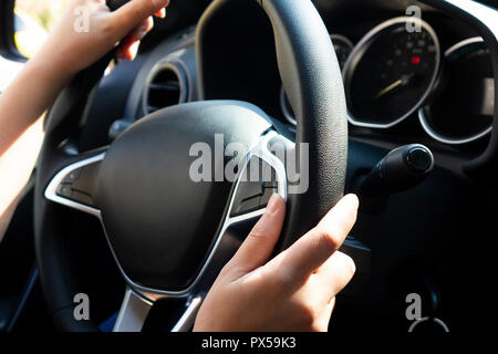 Mains de femme pilote au volant. Femme détient le volant des voitures de route, blurred Banque D'Images