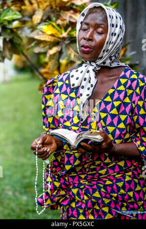 Femme en prière à Notre Dame d'Afrique sanctuaire catholique, Abidjan, Côte d'Ivoire. Banque D'Images