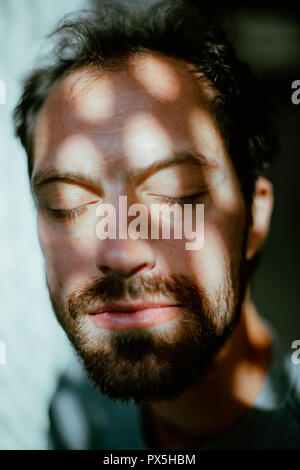 Photo en gros plan du jeune homme aux yeux clos relaxant Banque D'Images